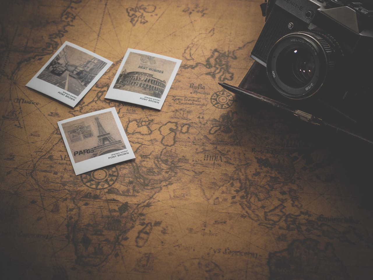 Vintage style still life with a camera, map, and travel photos. Perfect for travel enthusiasts.